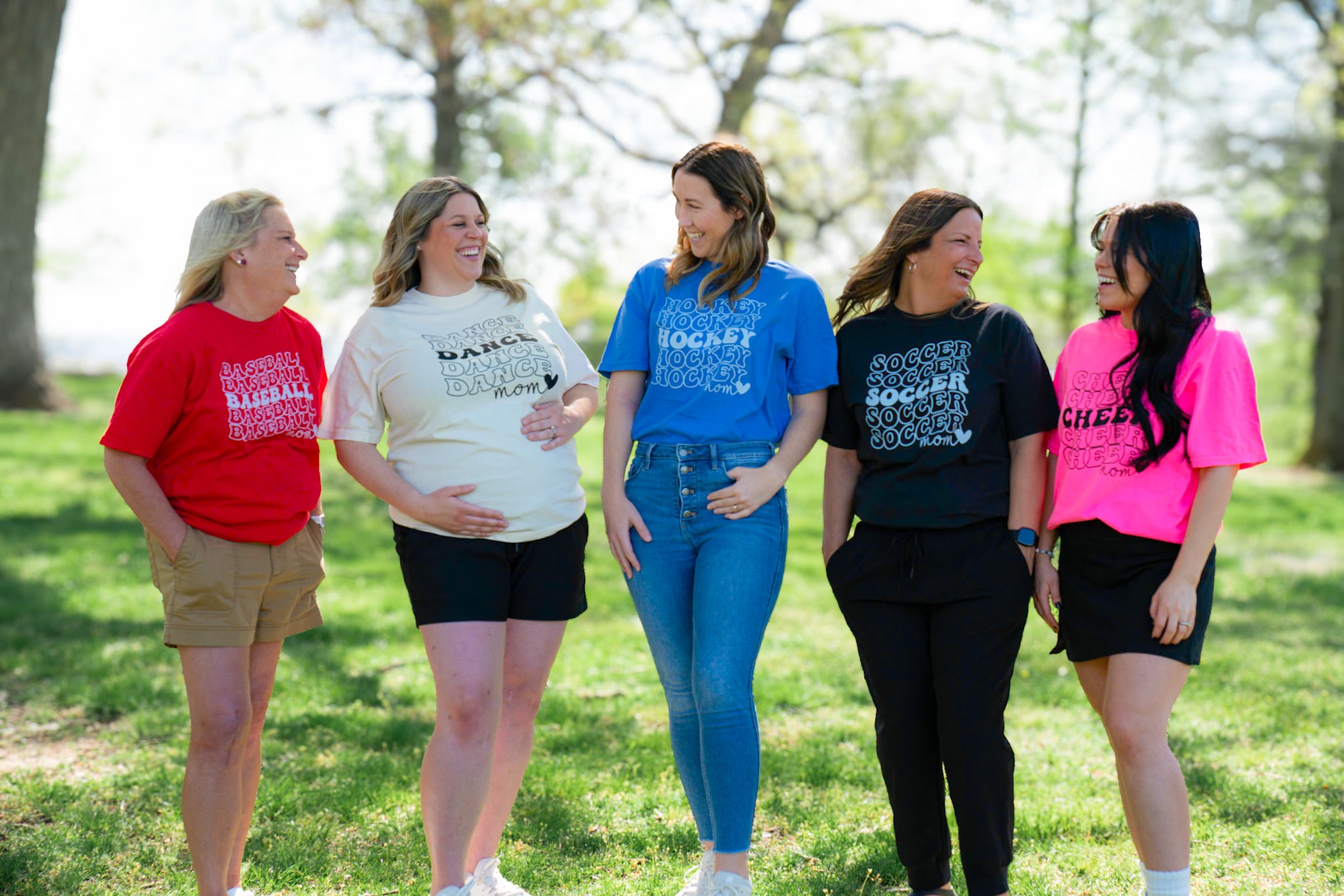 Group of moms laughing wearing sports shirts